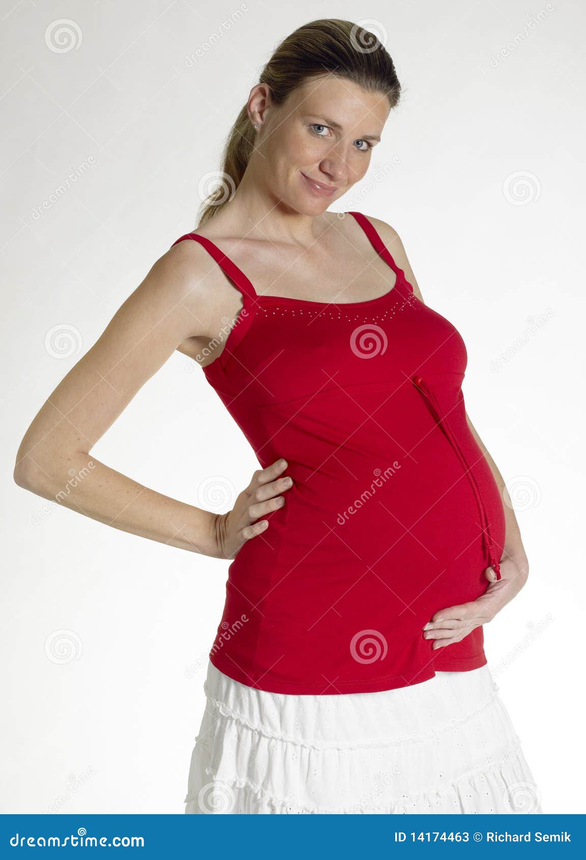 беременная женщина. Belly ее женщина удерживания супоросая стоящая