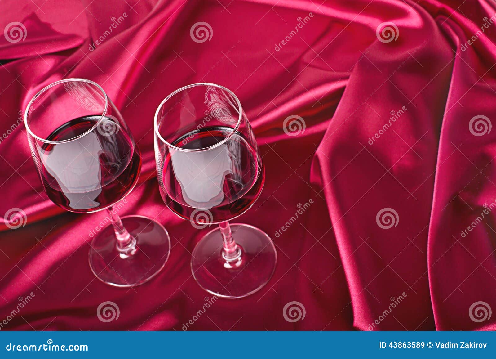 вино стекел 2. 2 бокала с красным вином на красном шелке