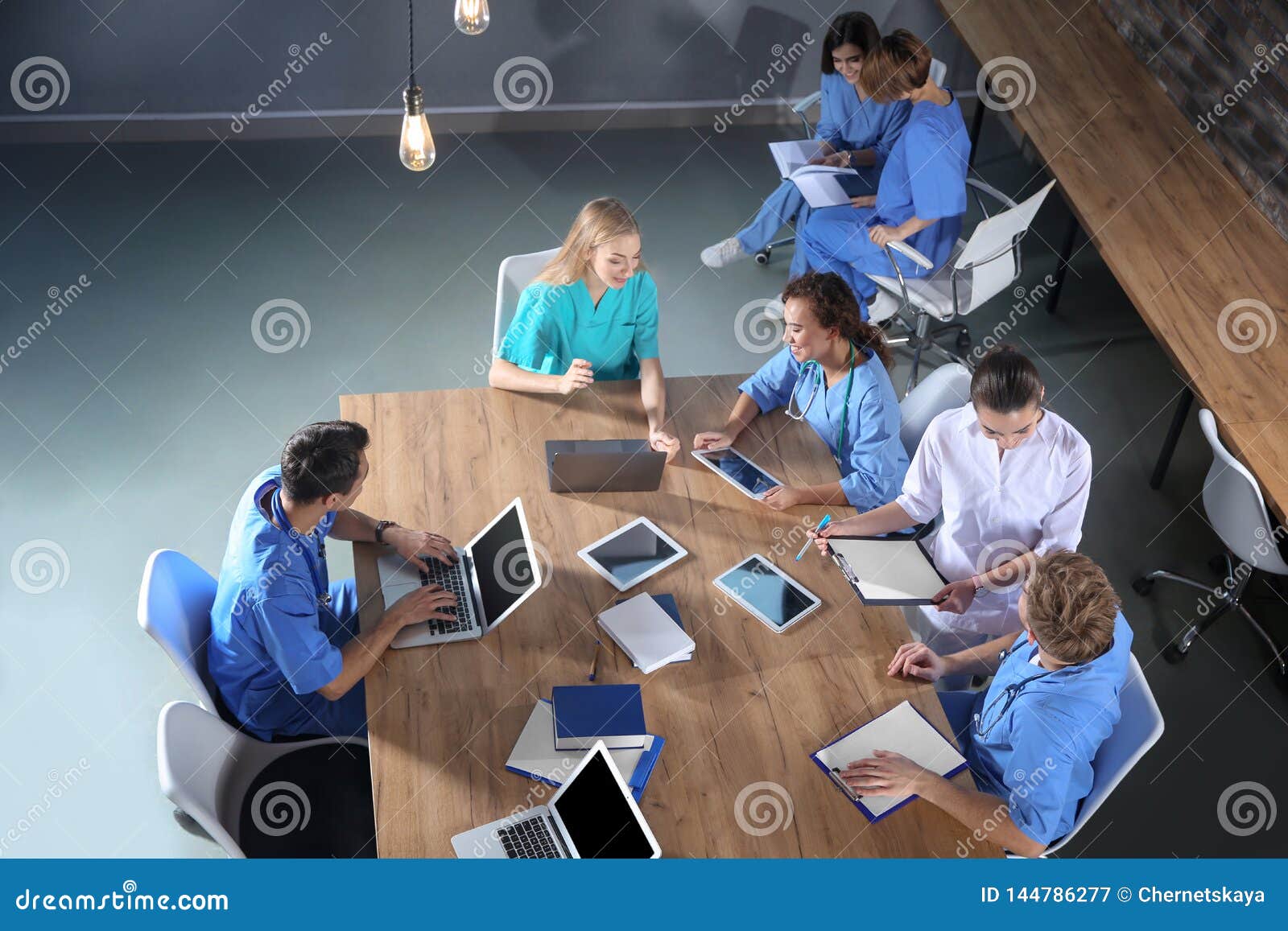 Группа в составе студент-медики с устройствами в коллеже, взгляд сверху