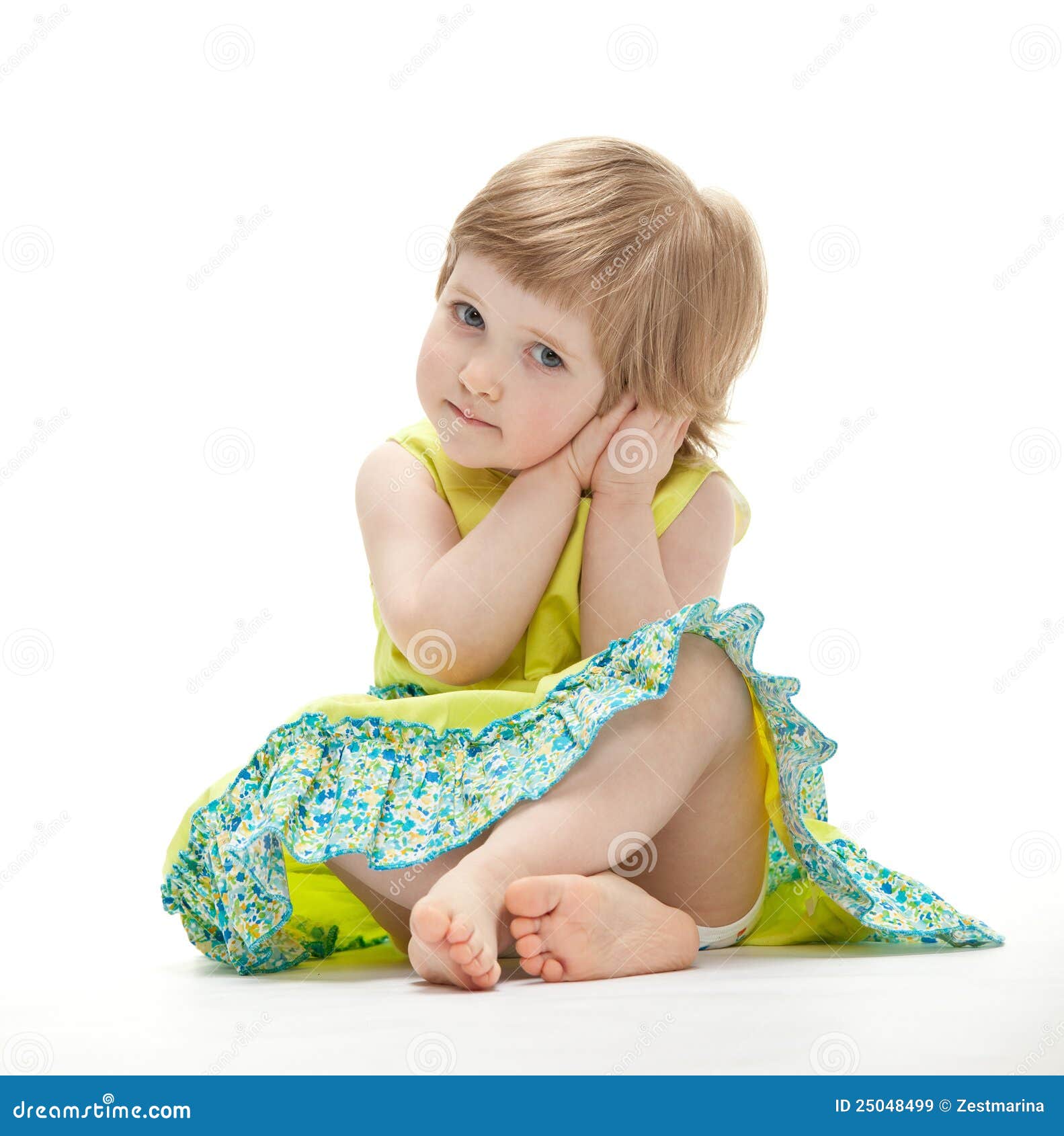 Маленькая девочка сидит на полу в платье