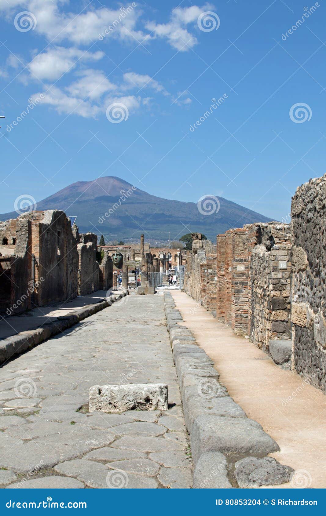 Держатель Versuvius от улицы в Помпеи. Держатель Versuvius - вулкан возвышаясь в задней земле Вулкан извергал в AD49 когда личинка пропустила через Помпеи и Herculenum