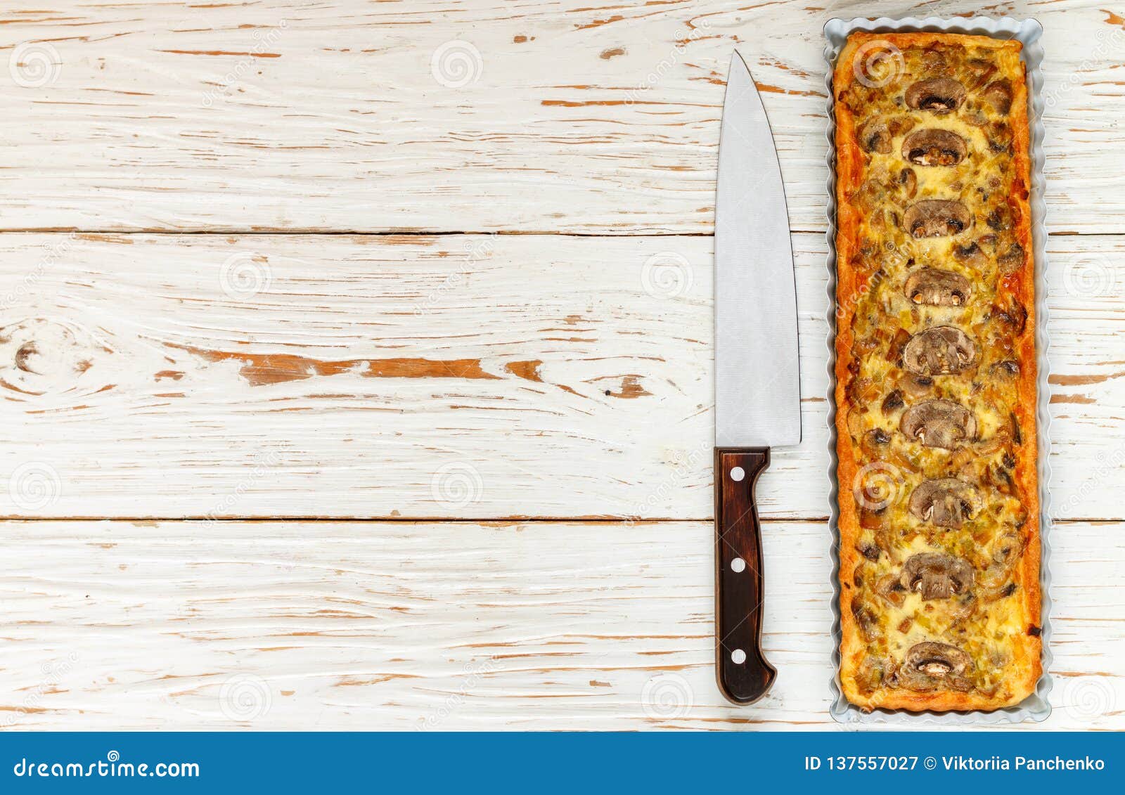 Домодельный пирог с грибами, лук-пореем, сыром и тимианом на белой деревенской предпосылке Традиционный торт закуски и нож на таблице Селективный фокус