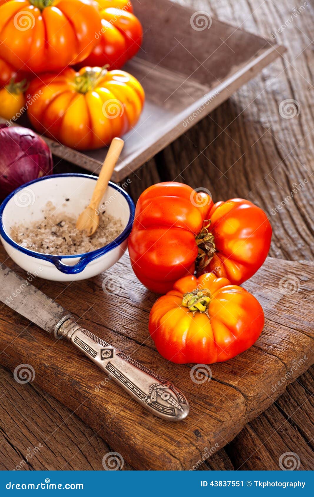Жалуйтесь томаты, шар соли с ложкой и нож Стоковое Изображение .