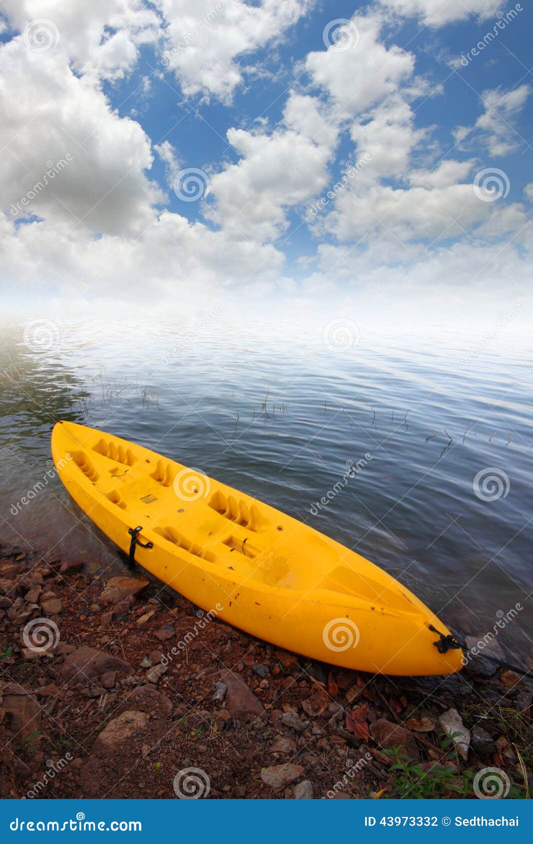 Желтый каяк в озере и небе