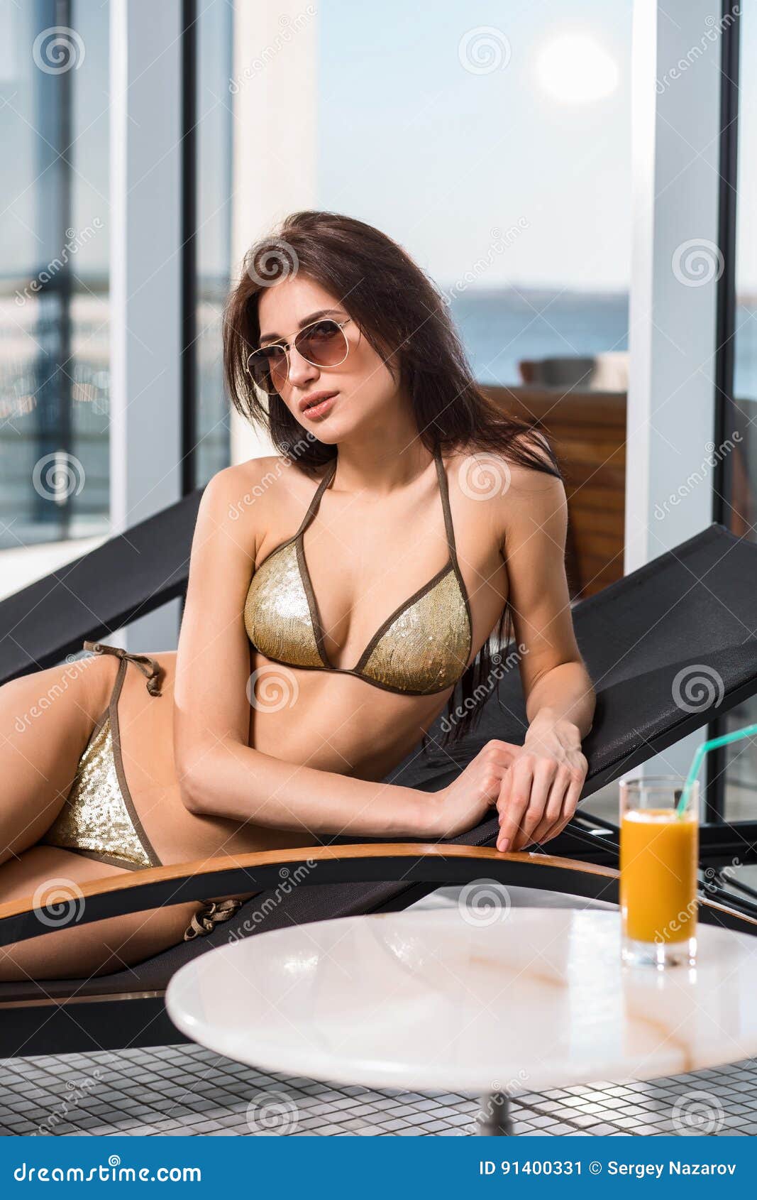 женщина воды спы здоровья ноги внимательности тела Женщина с совершенным телом в бикини лежа на deckchair бассейном на гостинице курорта курорта