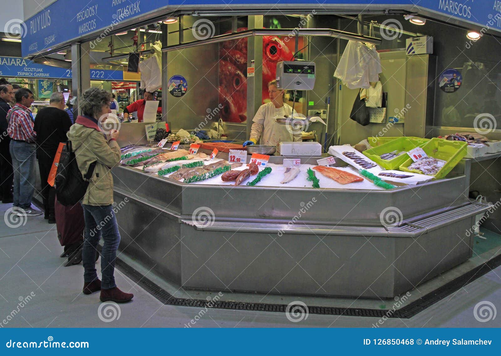 Женщина продает рыб и продукта моря в Бильбао, Испании. Бильбао, Испания - 27-ое мая 2018: женщина продает рыб и продукта моря на рынке в Бильбао, Испании