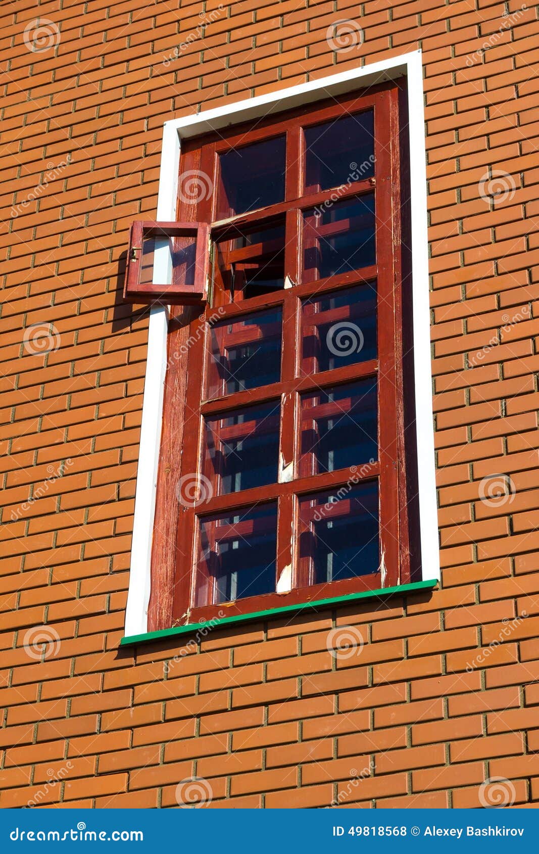 здание кирпича украшает снаружи к используемому окну стены. Красная коробка с открытым окном на кирпичной стене здания