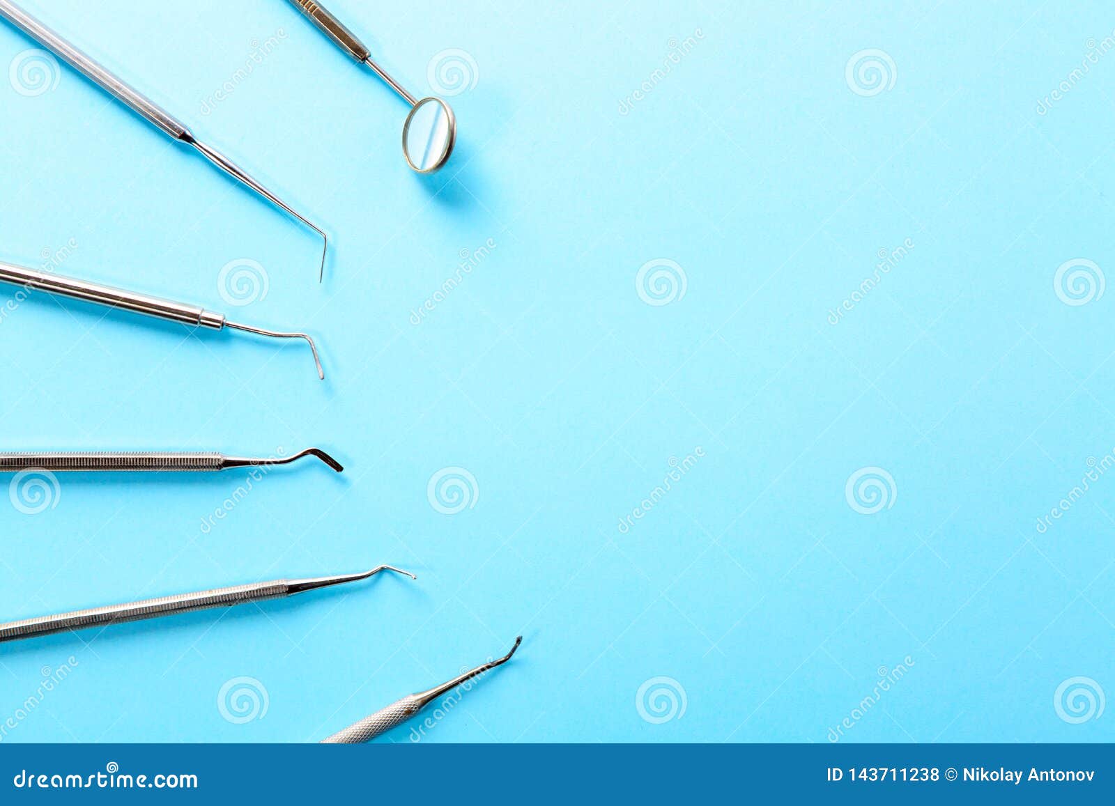 Инструменты дантиста Профессиональные стальные зубоврачебные аппаратуры с зеркалом на светлом - голубая предпосылка с открытым космосом Зубоврачебная концепция здоровья и teethcare