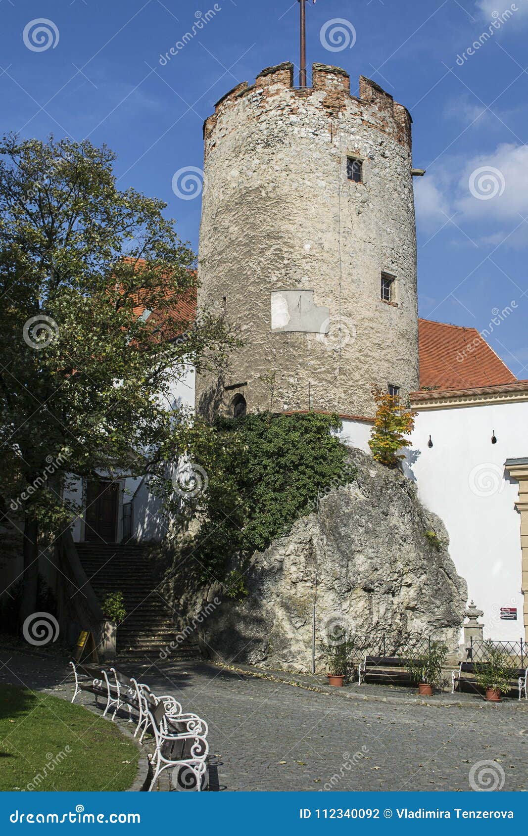 Историческая каменная круглая башня с белыми стендами под ей в старом городке Moravian