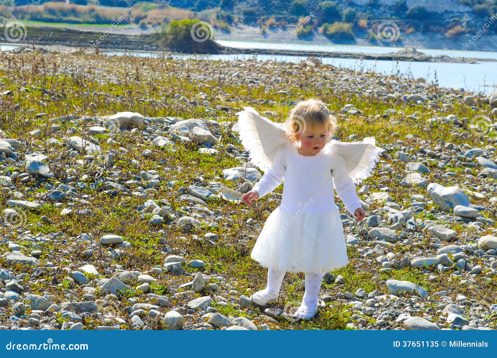 Красивая маленькая девушка ангела пришла от рая. Красивый маленький ангел пришел от рая. Милая маленькая девочка с белым платьем и белыми крылами.