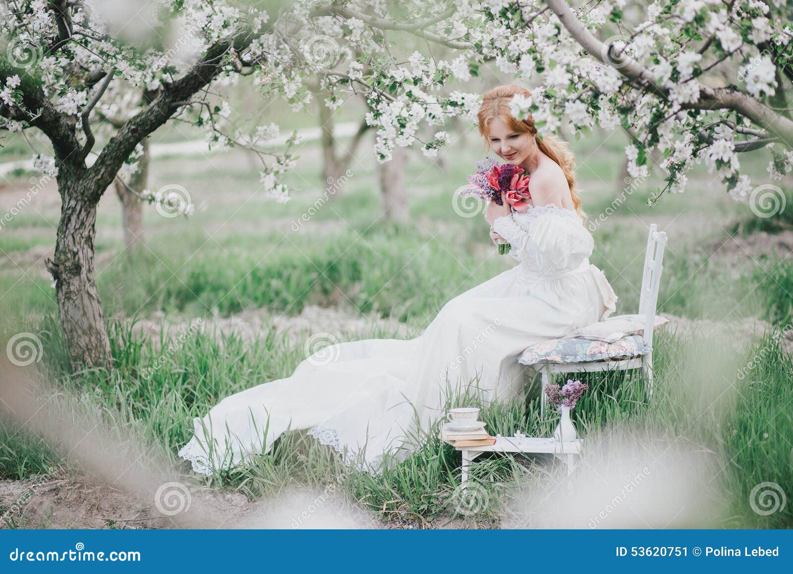 Красивая невеста в винтажном платье свадьбы представляя в зацветая саде яблока 9 тюльпанов весны настроения пестроткаными установленных изображениями чудесных Молодая женщина в белом винтажном платье