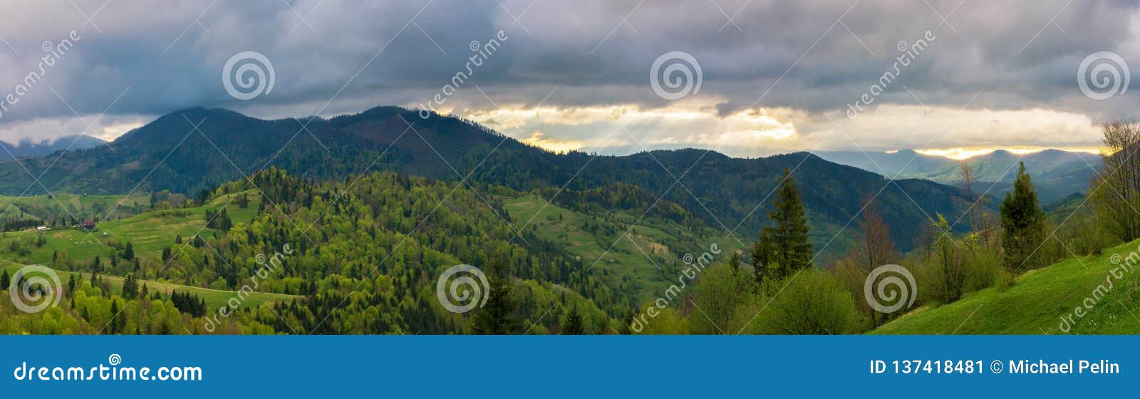 Красивая панорама гористой сельской местности чудесный ландшафт весеннего времени заросший лесом Rolling Hills небо overcast с лучами солнца в расстоянии