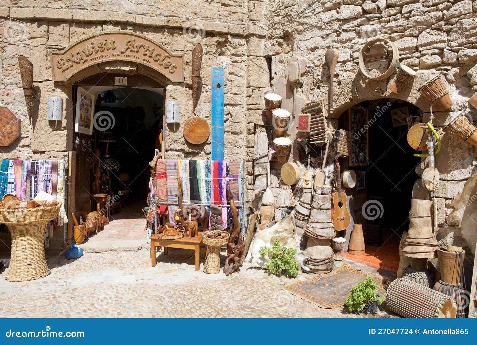 Магазины на Essaouira. Марокко: магазины среди стен города Essaouira укрепили город. Essaouira город в западной морокканской хозяйственной зоне Marrakesh-Tensift-Al Haouz, на атлантическом свободном полете. С XVI век, город также был знан своим португальским именем Mogador или Mogadore. Имя Berber значит стену, справку к крепостным стенам которые первоначально заключили город.
