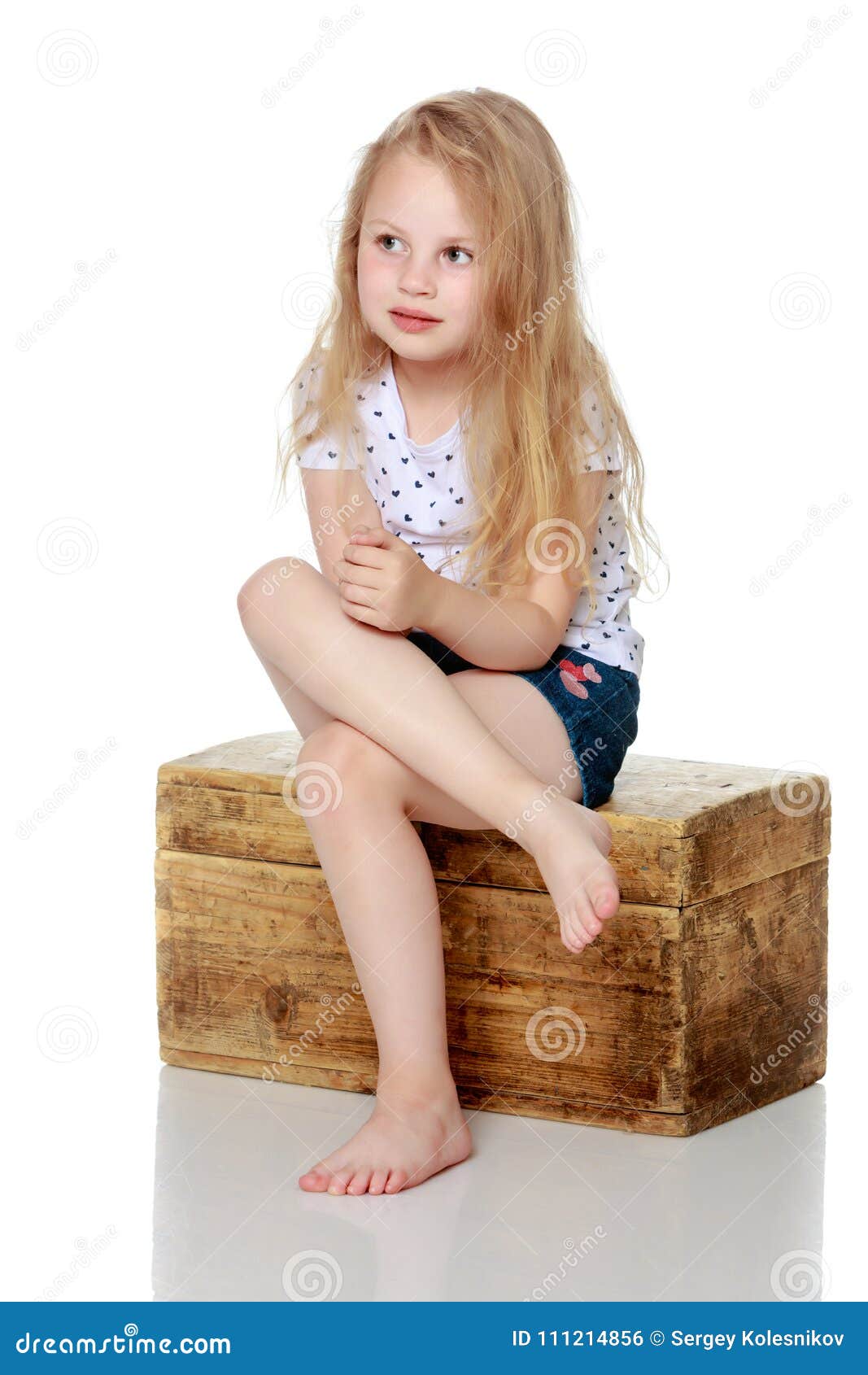 Маленькая девочка сидит нога на ногу