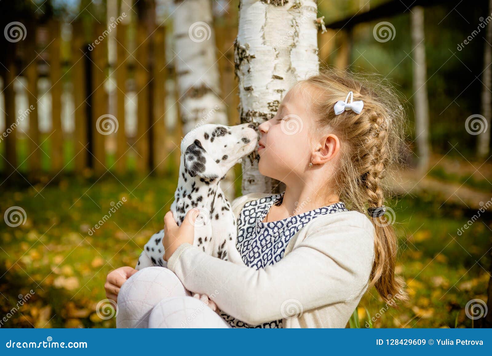 Милая девушка целуя ее щенка Doggy на деревянной предпосылке з