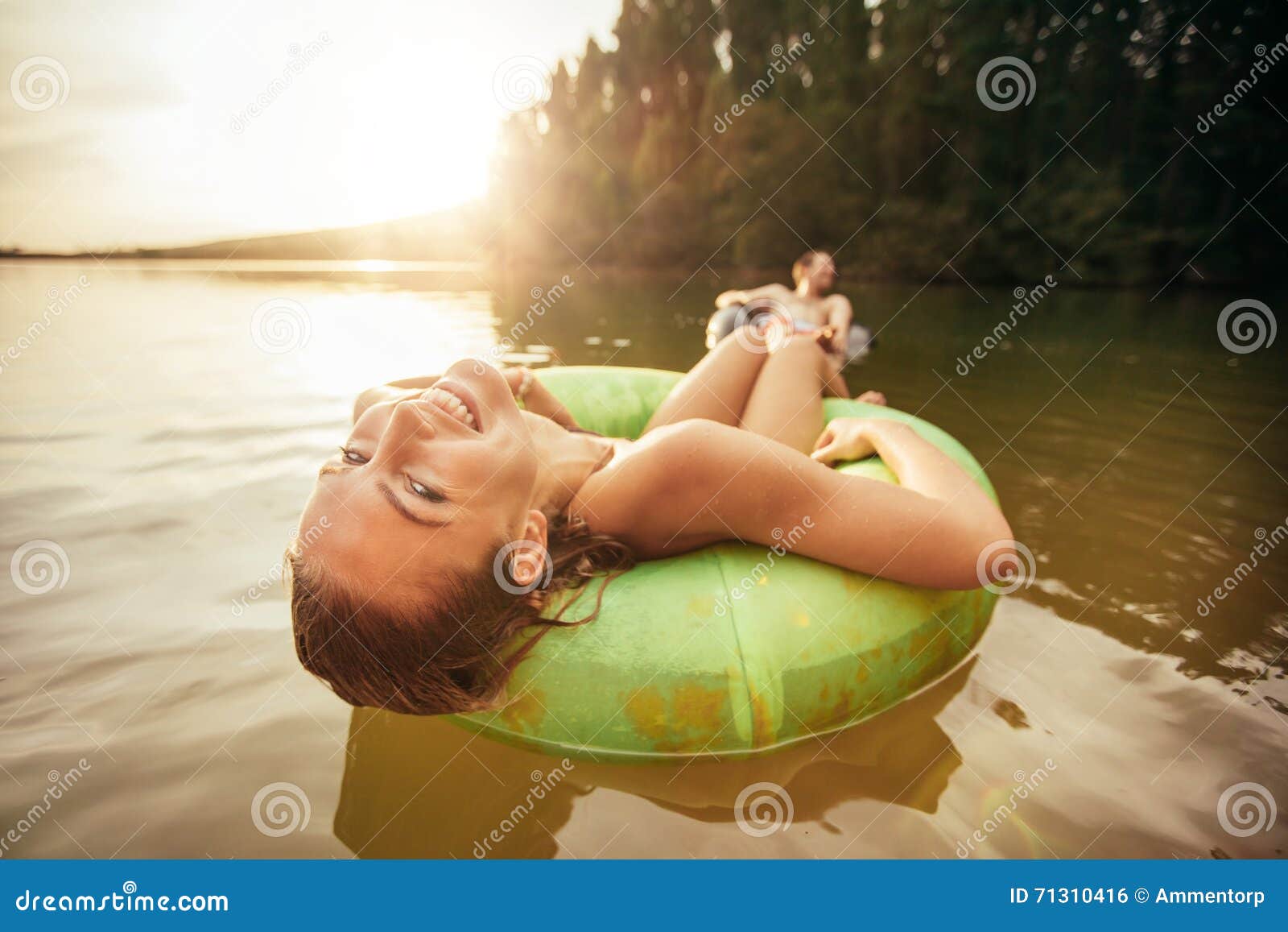 Молодая женщина ослабляя на автомобильной камере в воде Стоковое Фото .