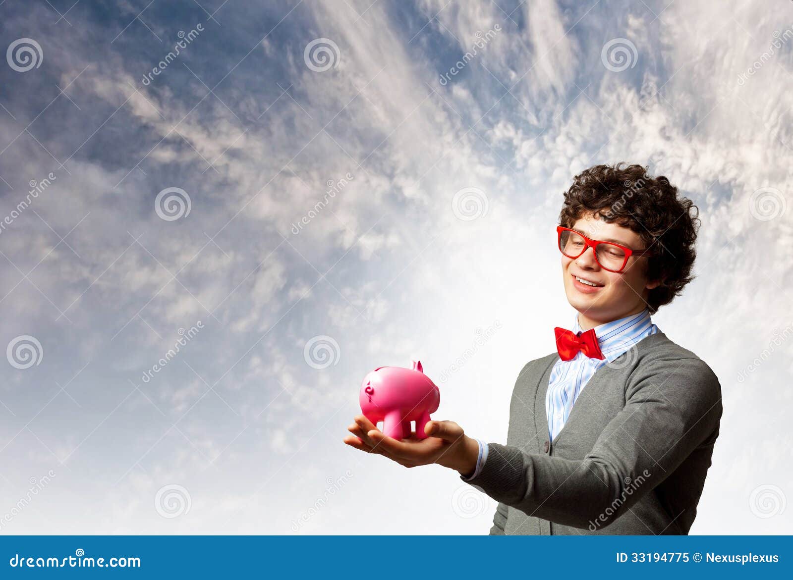 Молодой бизнесмен держа moneybox. Изображение молодого бизнесмена в красных стеклах держа moneybox