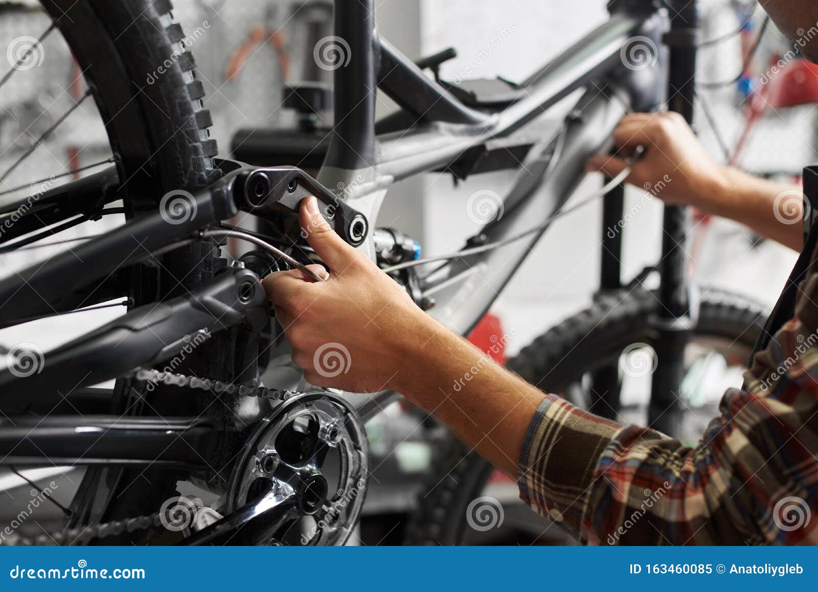 Мужской механик, работающий в мастерской по ремонту велосипедов с ...