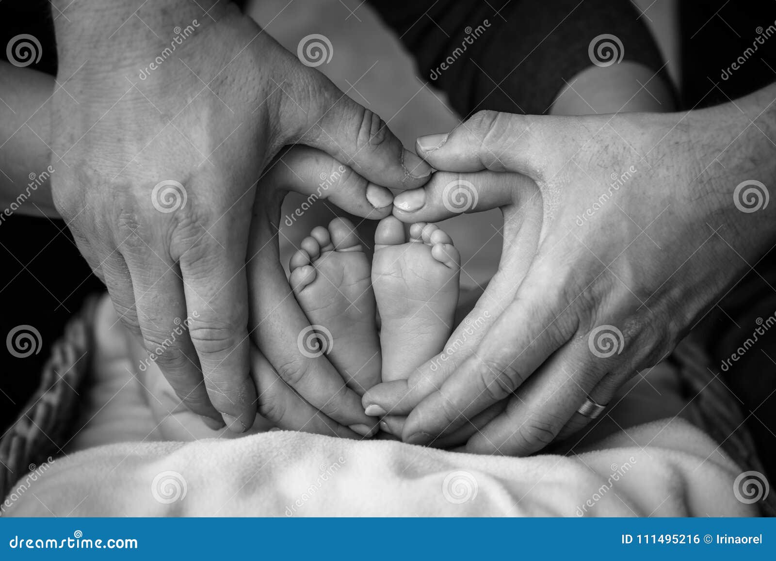 Ножки младенца в руках родителей