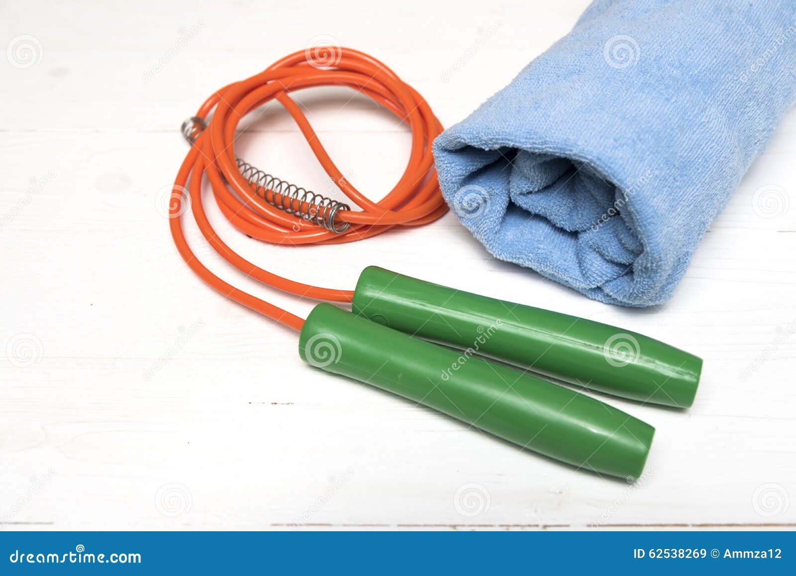 Оборудование фитнеса: полотенце, скача веревочка. Оборудование фитнеса: голубое полотенце, скача веревочка на белой деревянной таблице