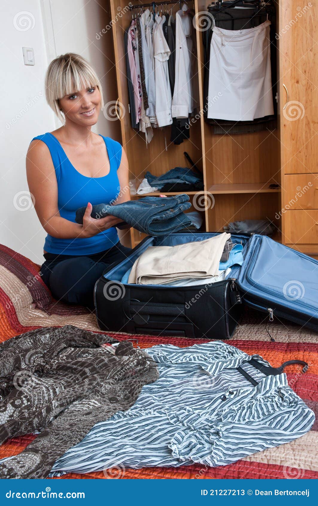 одежды пакуя женщину. привлекательная спальня одевает ее женщину упаковки багажа