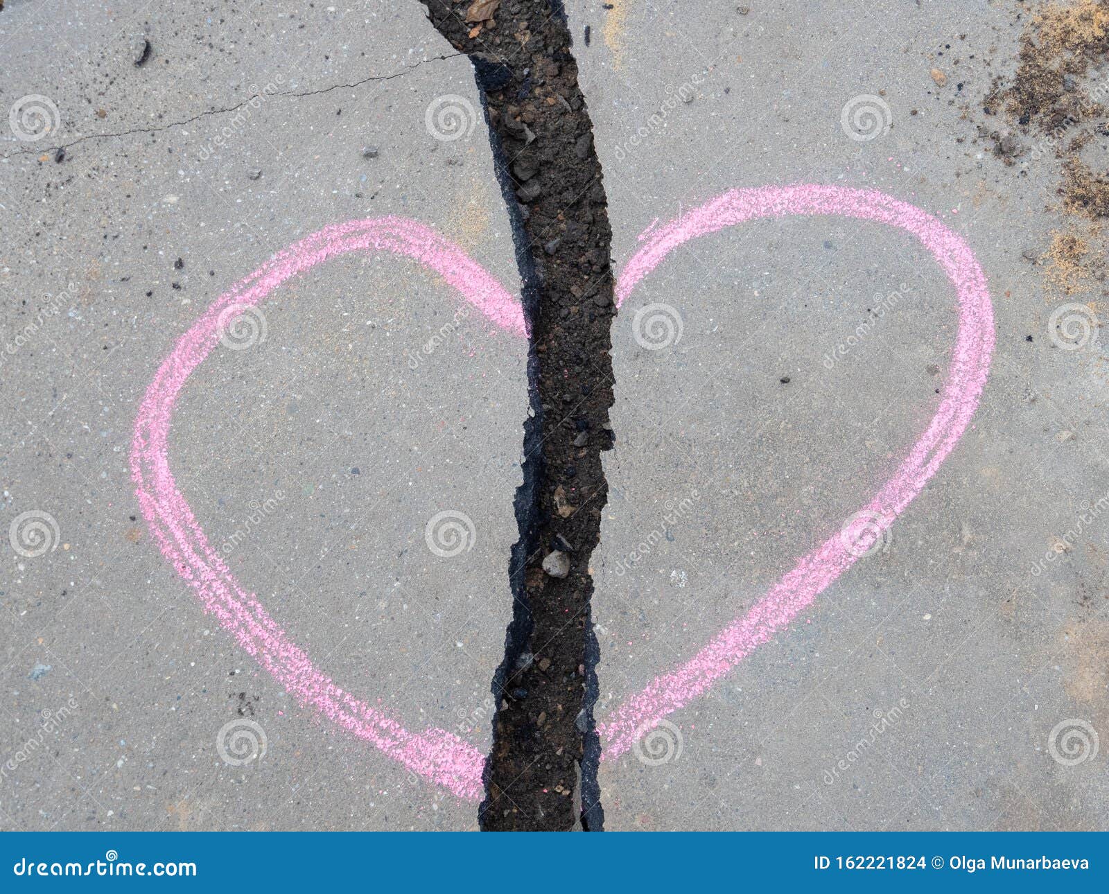 Он нарисовал сердце в розовом меле на асфальте, через который проходит ...