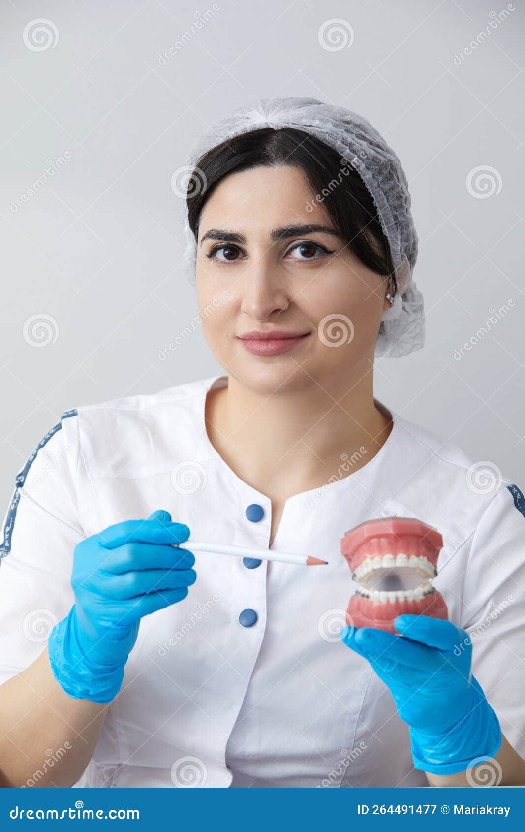 ортодонтист, показывающий модель челюсти человека с проволочными ...