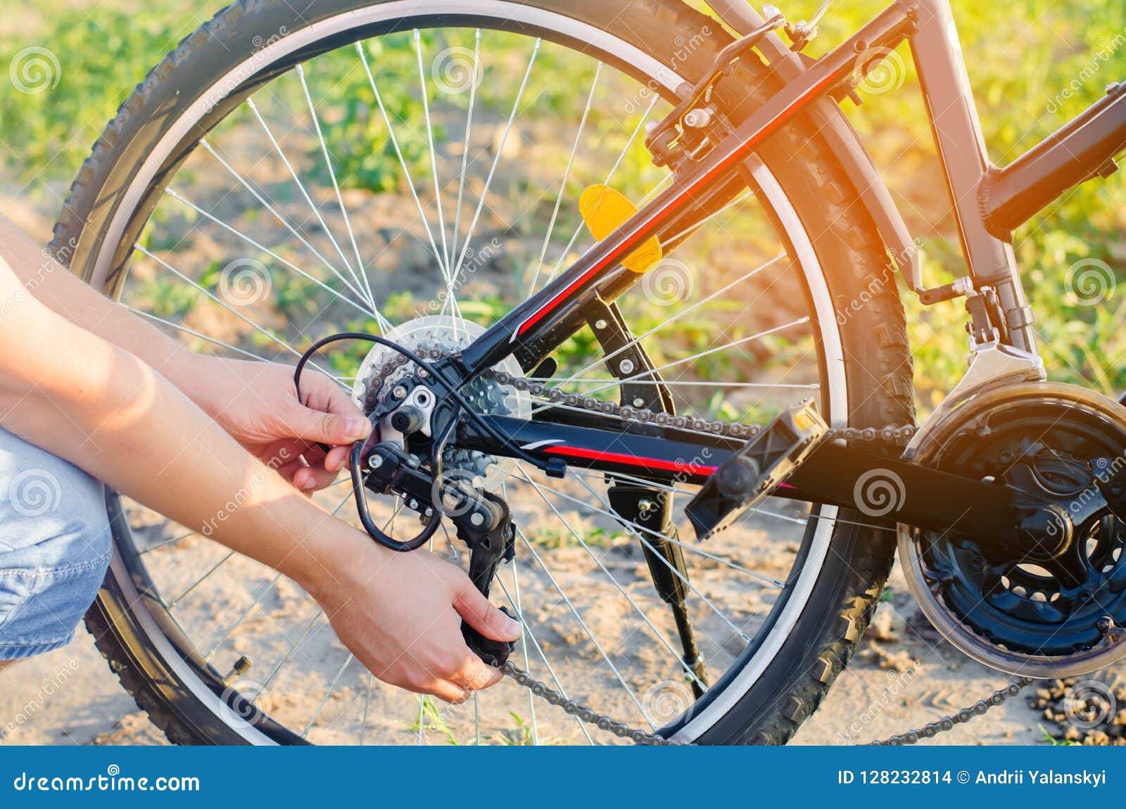 Парень ремонтирует велосипед цепной ремонт unratitude на дороге, перемещение велосипедиста, конец-вверх