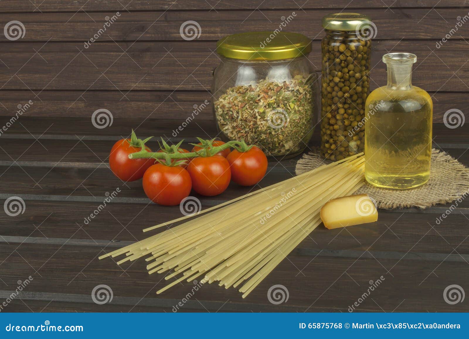 Подготавливать домодельные макаронные изделия Макаронные изделия и овощи на деревянном столе диетическая еда Макаронные изделия, томаты, лук, оливковое масло и базилик на деревянной предпосылке