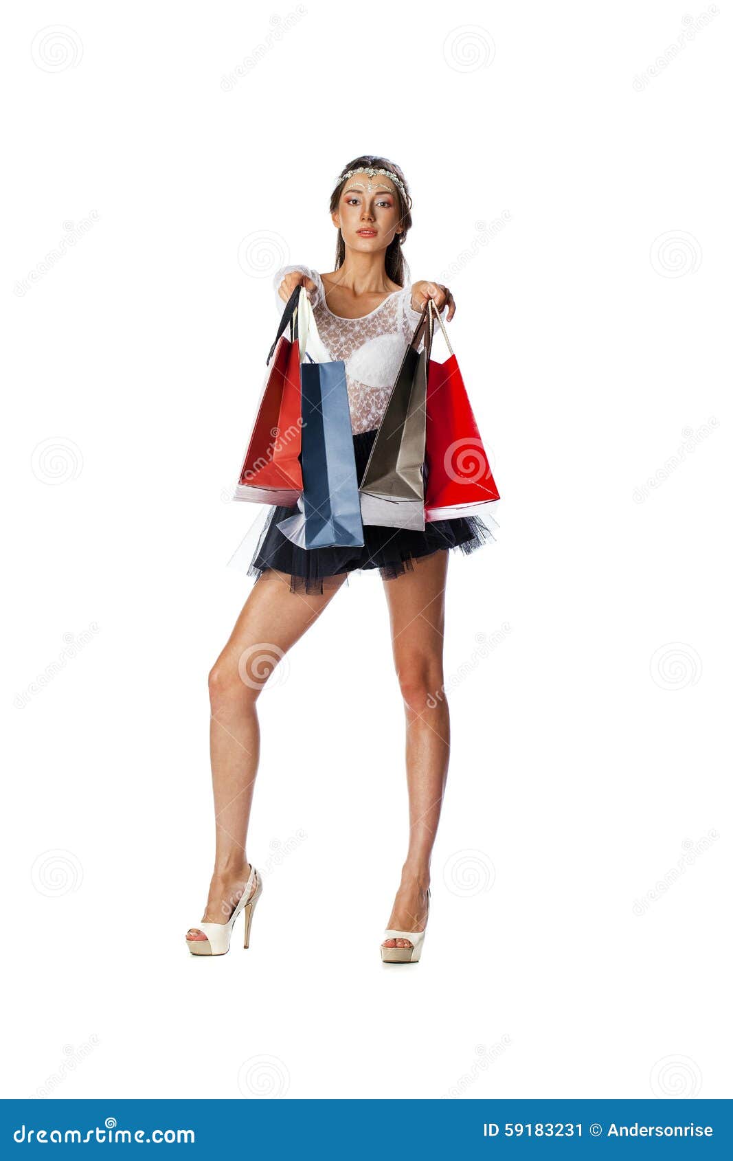 Портрет красивой молодой женщины брюнет представляя с покупками. Полнометражный портрет красивой молодой женщины брюнет представляя с хозяйственными сумками, изолированный на белой предпосылке