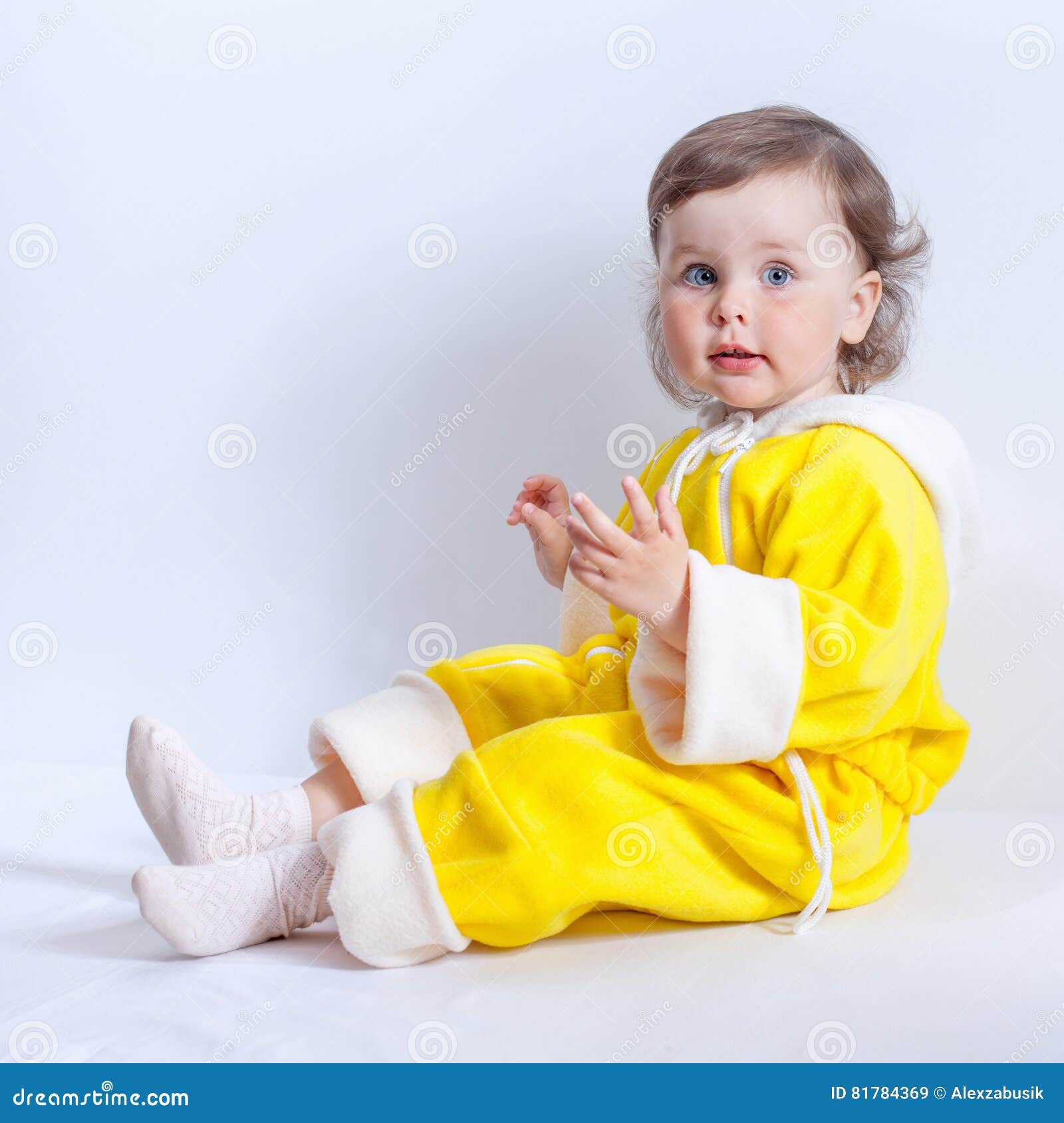 Портрет очаровательного младенца в желтых Rompers младенца с клобуком ...