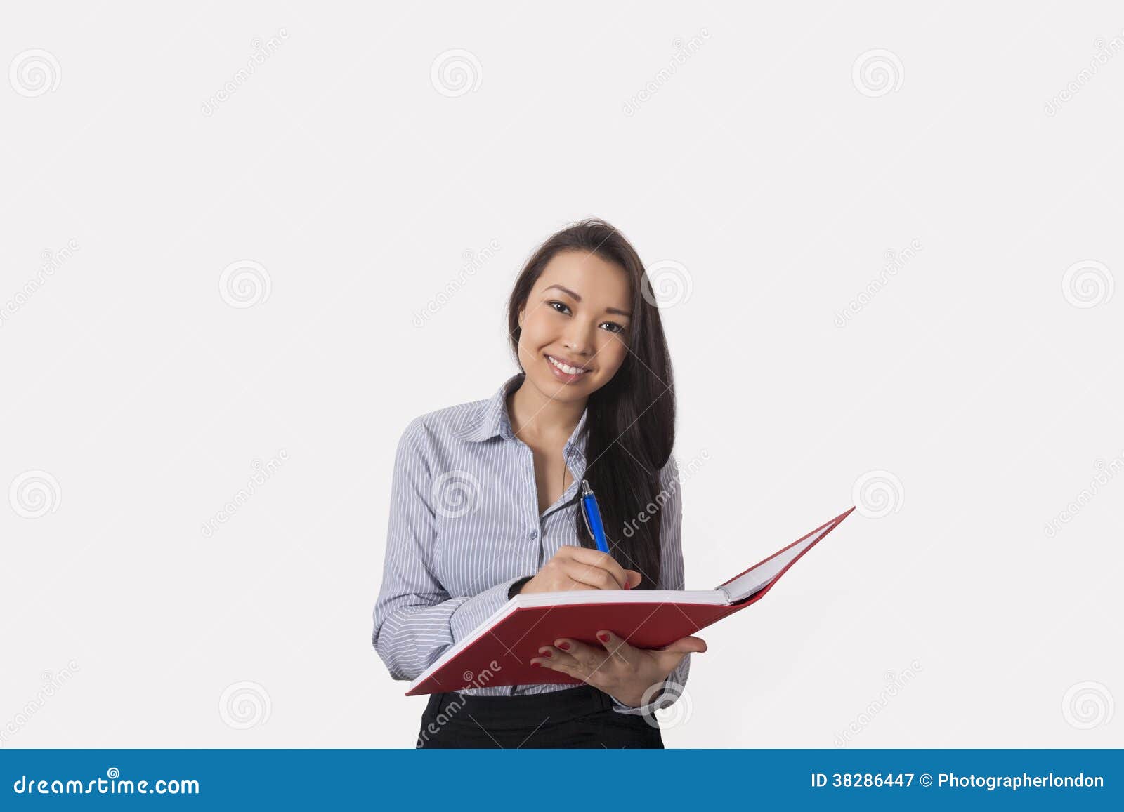 Портрет счастливой коммерсантки с книгой и ручки над белой предпосылкой
