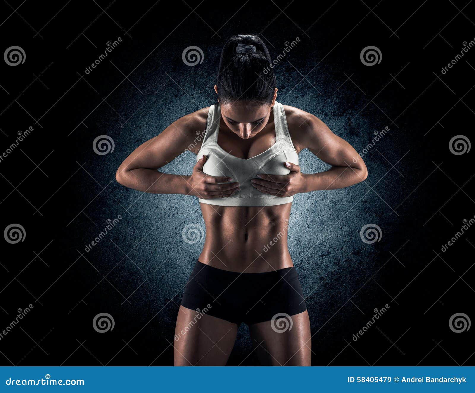 Привлекательная женщина фитнеса, натренированное женское тело, portrai образа жизни. Молодая женщина фитнеса показывая ее совершенное ваяемое мышечное и плотное тело