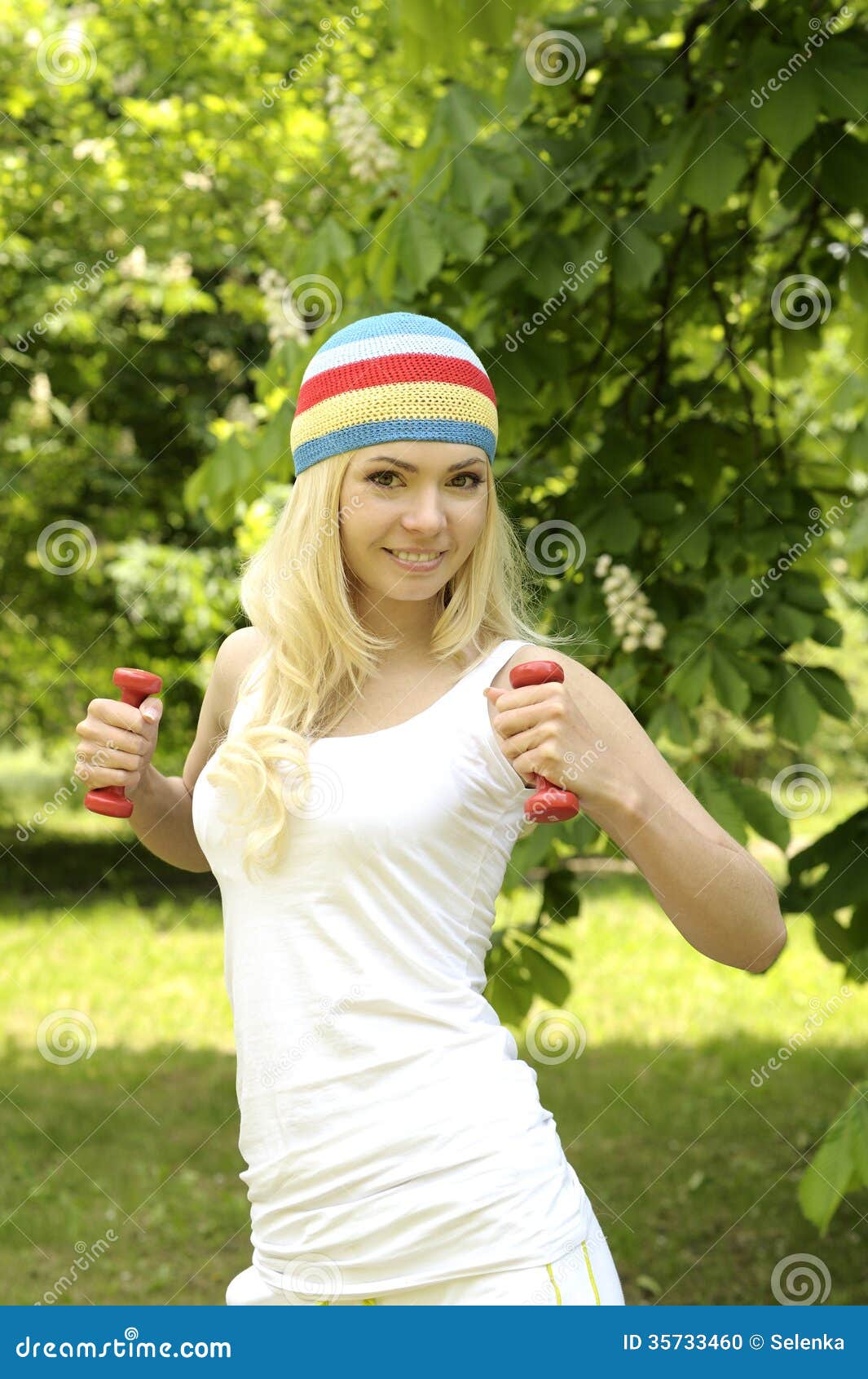 Разработка девушки блондинкы усмехаясь sporty внешняя в парке.