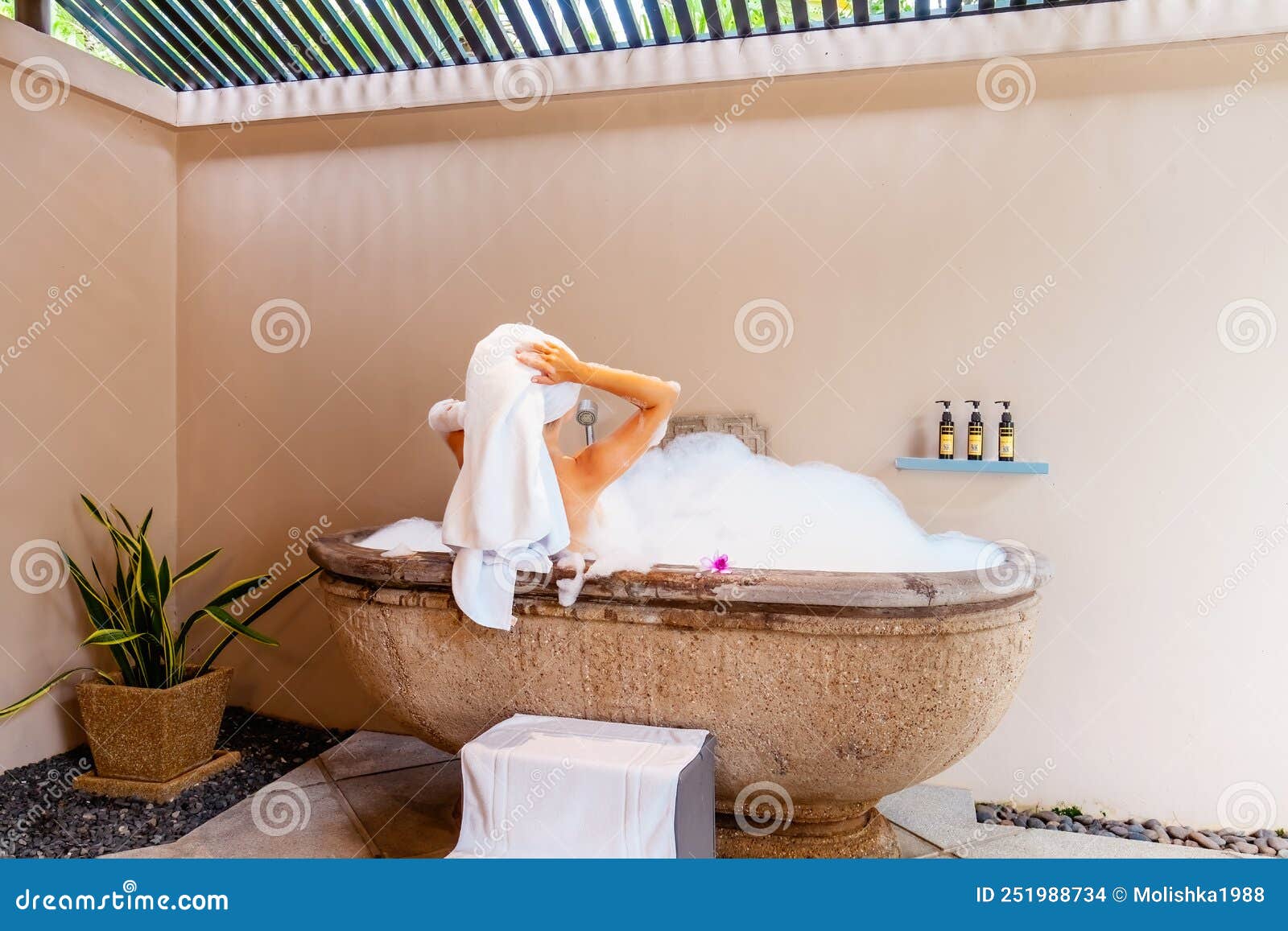 Симпатичная девушка с открытой банкой крема в ванной у зеркала