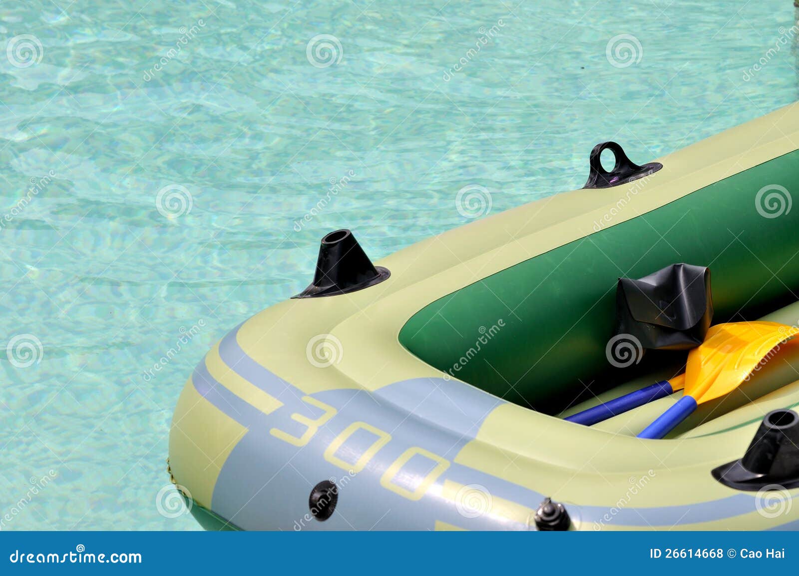 Резиновая шлюпка на воде. Светлая резиновая шлюпка плавая на воду, показанную как спорт и зрелищность воды лета.