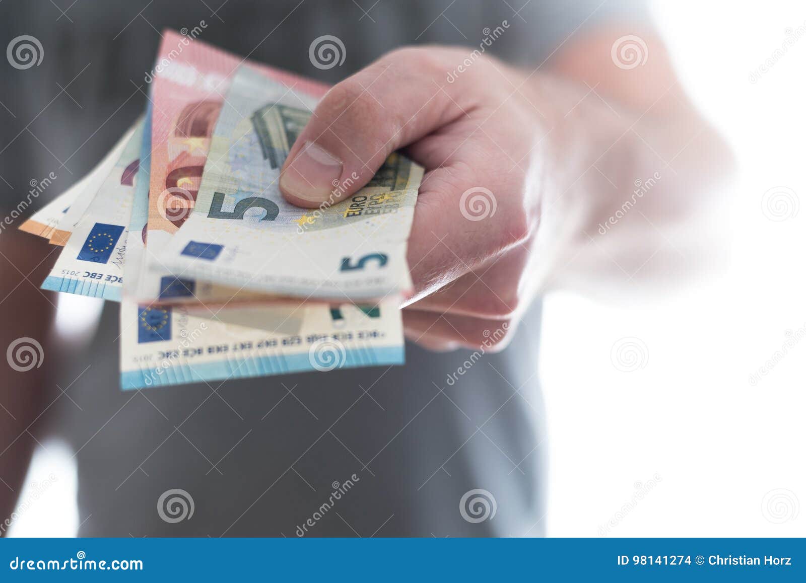 Рука мужск человека вручая над банкнотами евро. Рука мужск человека вручая над несколько различными счетами евро