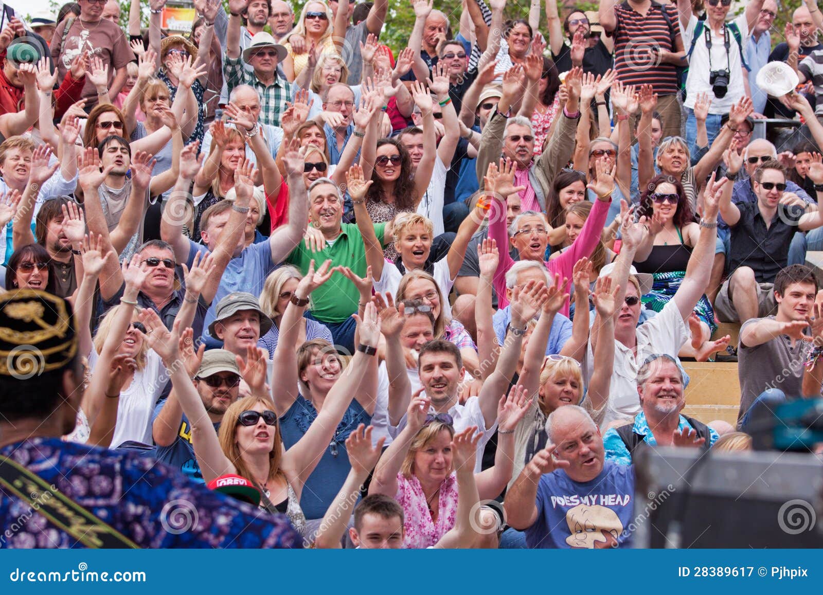 Рукоятки поднятые в одобрении. БРИСТОЛЬ, Великобритания, 21-ое июля 2012. Аудитория показывает свое благодарность для поступка на 41st празднестве гавани Бристоля. Возвращение погоды лета пробудило большие толпы присутствовать на самом большом случае своего вида в Европе