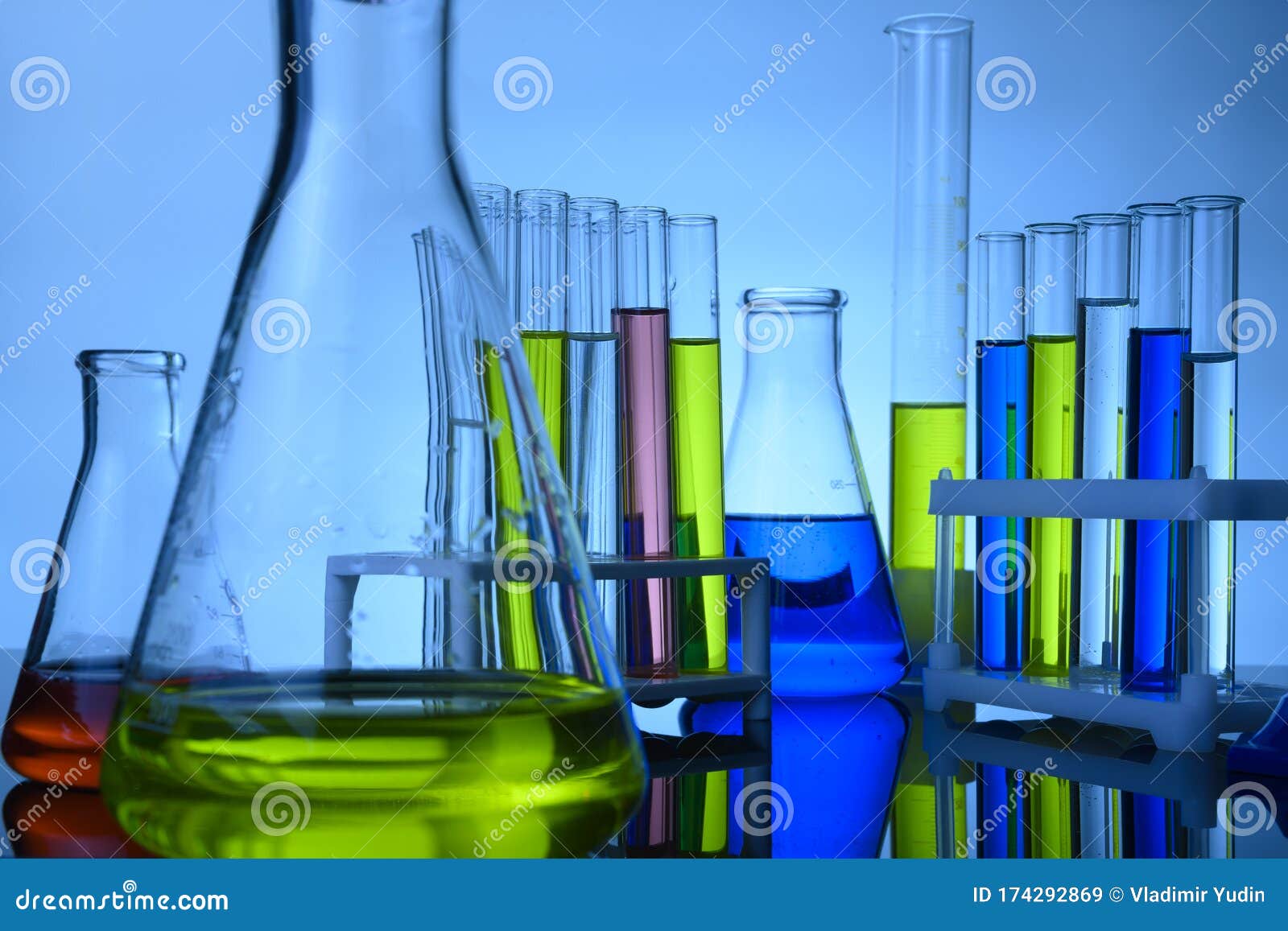 Склянки и в пробирке стоят в лаборатории с цветными химическими ...