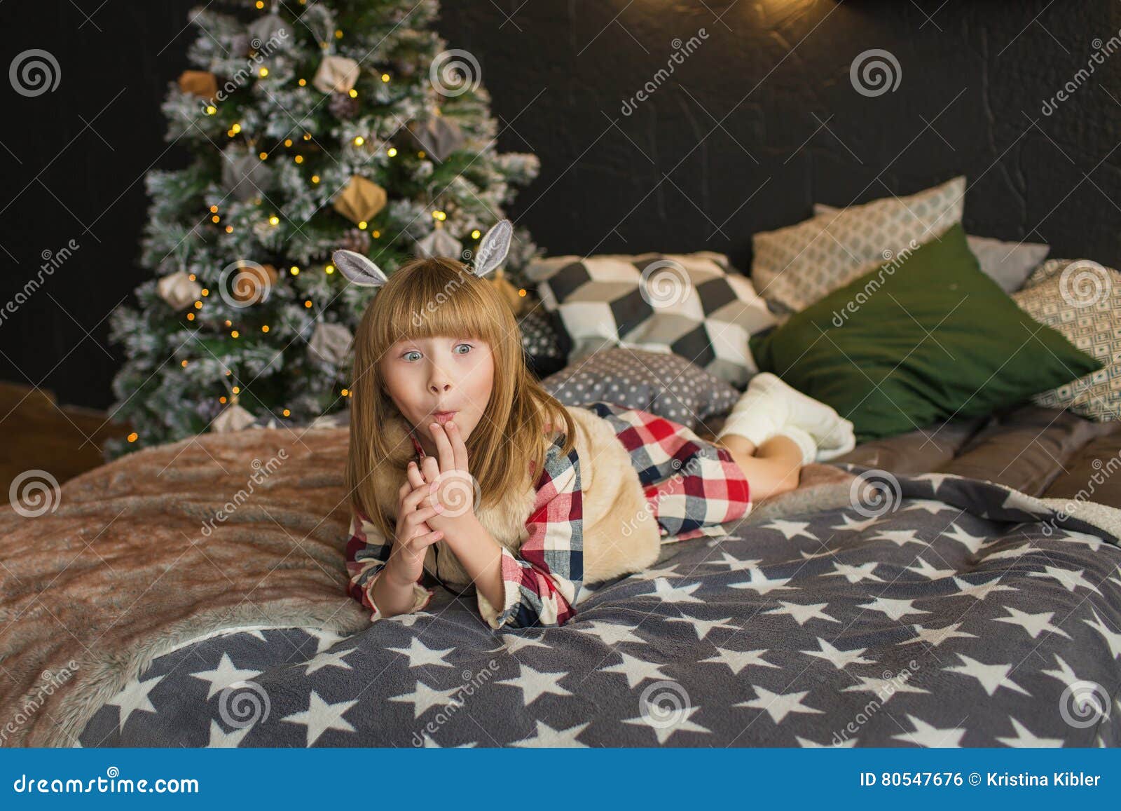 Смешная маленькая девочка лежит на кровати во времени рождества .