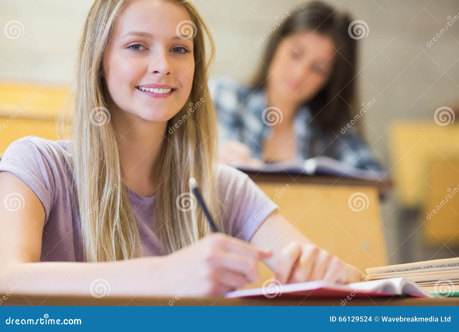 Студенты сидя около одина другого пока учащ Стоковое Фото - изображение ...