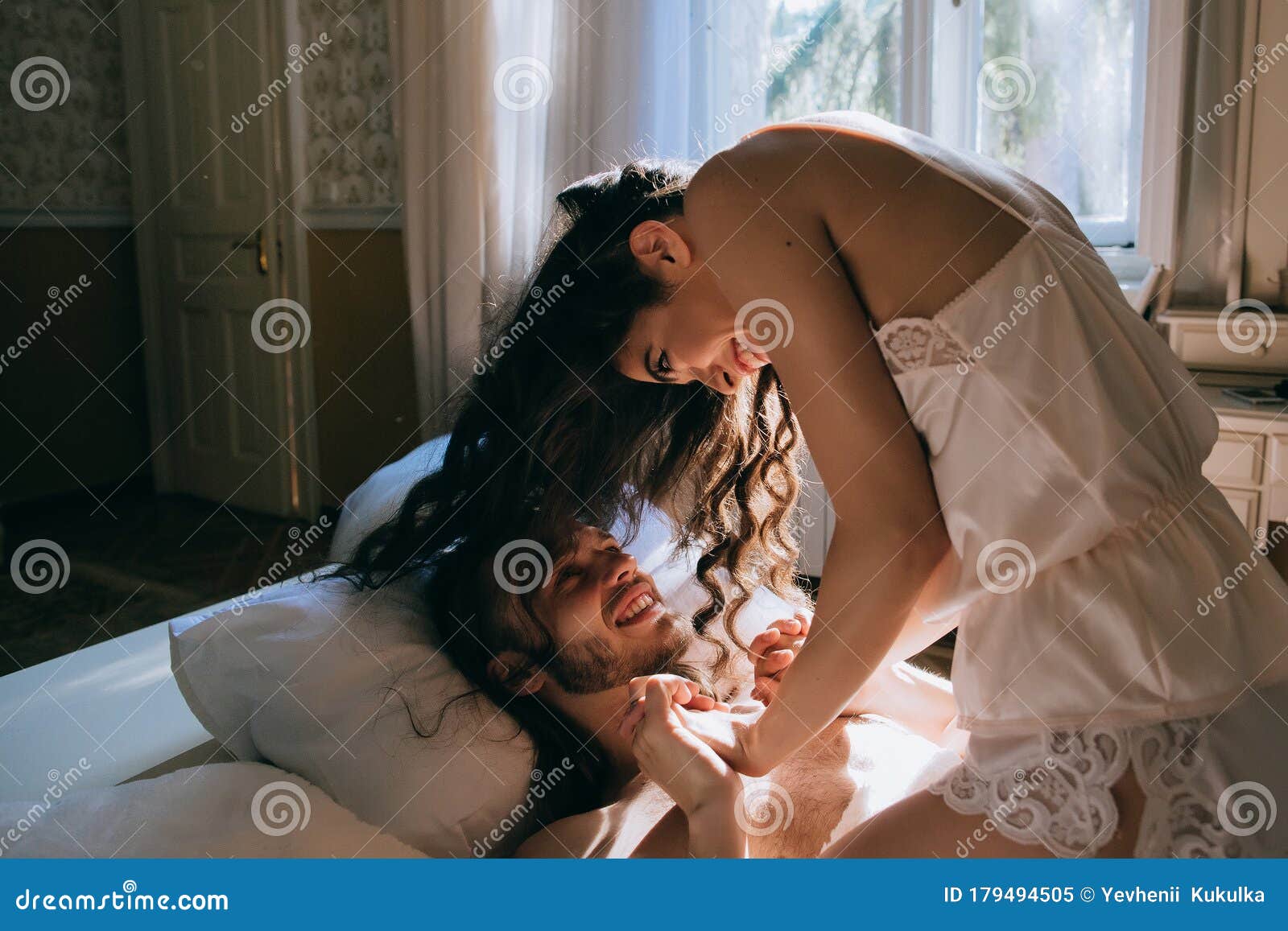 Молодая пара целуются в постели