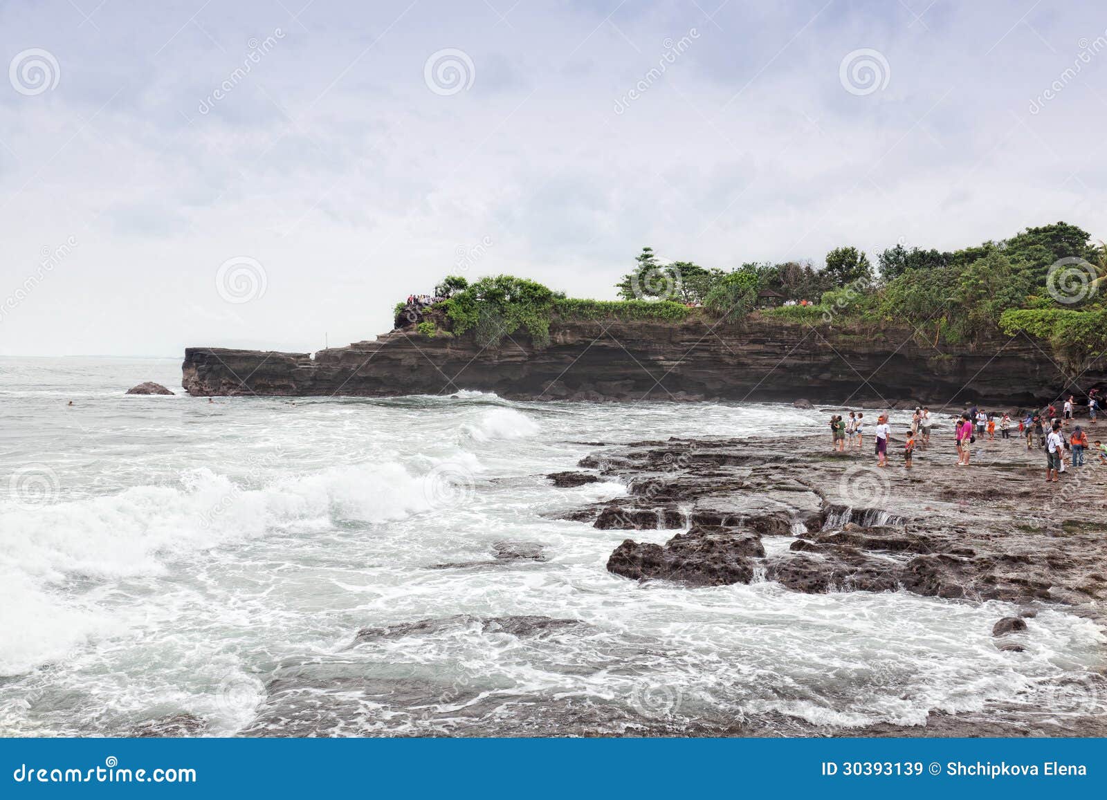 Туристы на океане плавают вдоль побережья около серии Tana виска, Бали, Индонезии 11.03.2012. Серия Tanah один из самых важных висков моря Бали