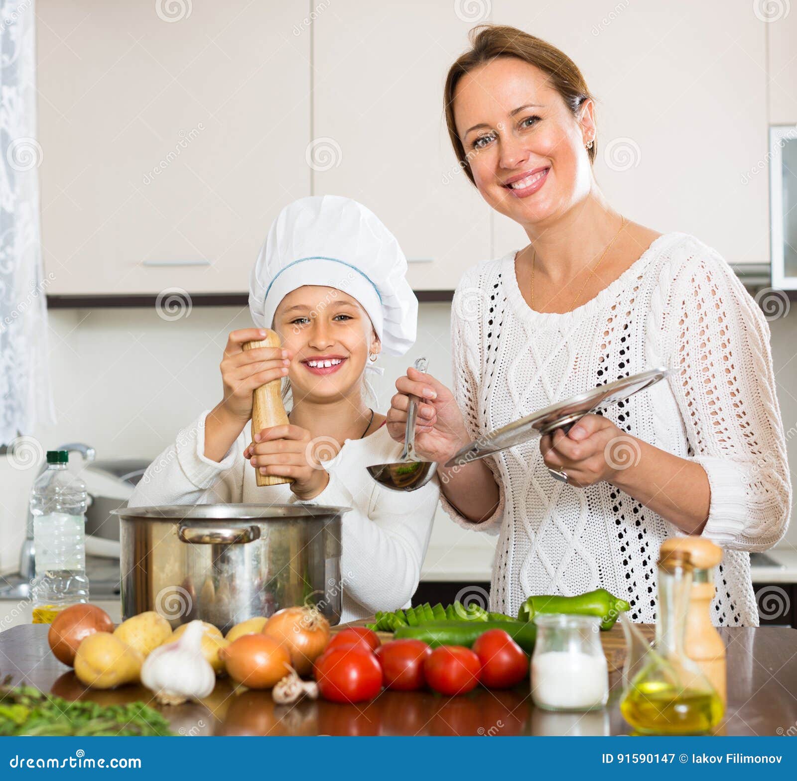 Усмехаясь девушка и мама на кухне Стоковое Изображение - изображение ...