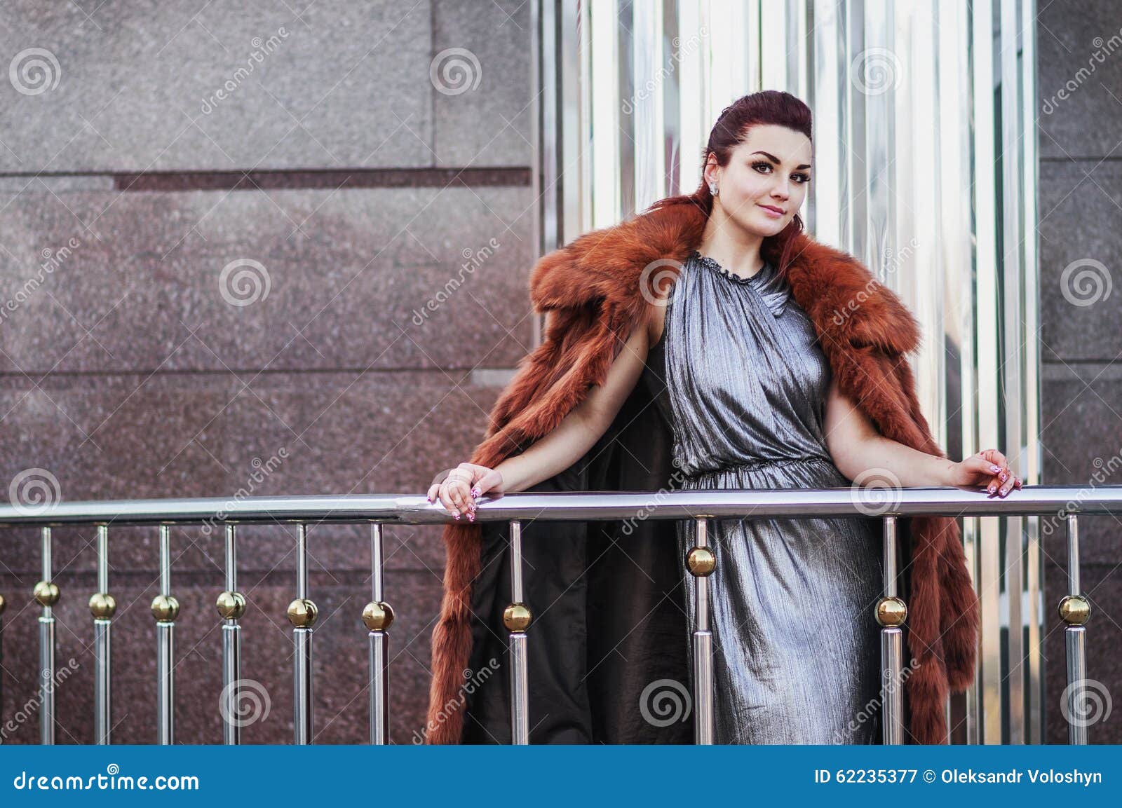 Фасонируйте внешнее фото сексуальной женщины очарования при темные волосы нося роскошную меховую шыбу и кожаные перчатки, представляя
