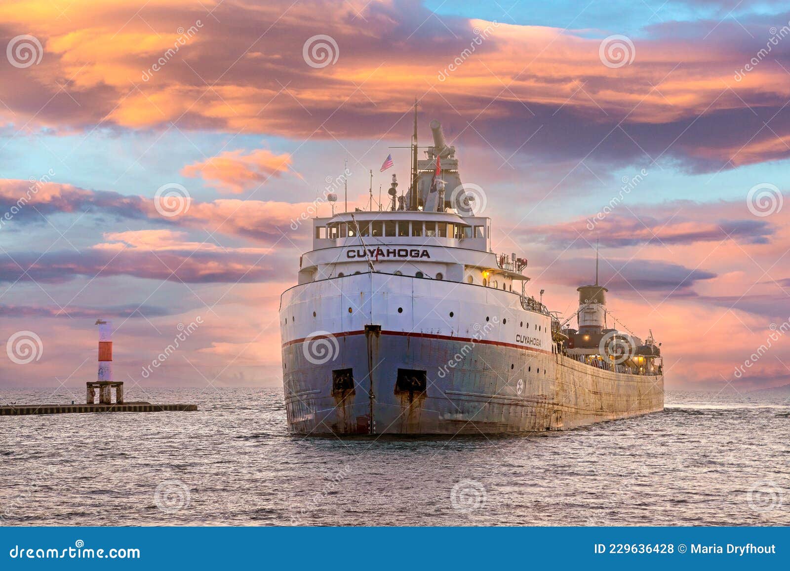фрахтователь в большой озерной гавани. Койахога-грузовой корабль, входящий в гавань Голландия в холлендском микрорайоне во время заката