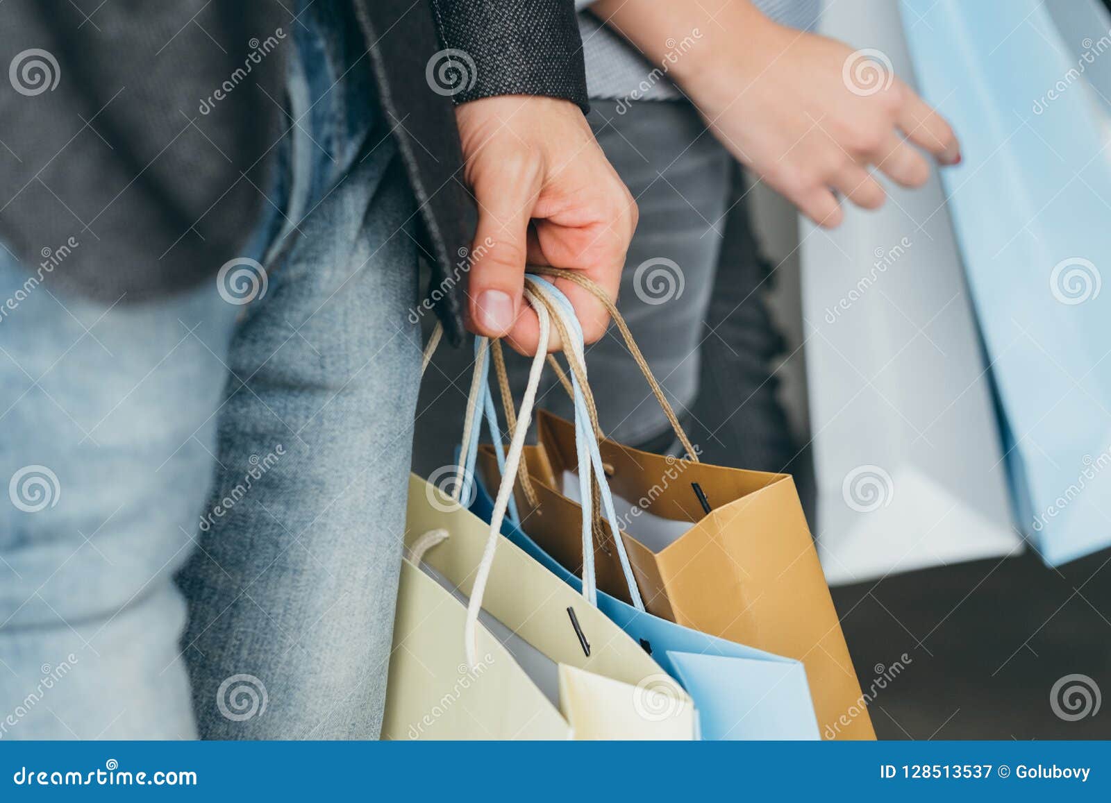 Человек продажи курортного сезона покупок кладет руку в мешки. Продажа покупок и курортного сезона подрезанная съемка руки людей с множественными сумками