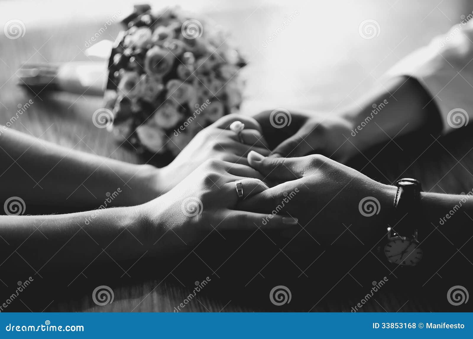一对年轻婚礼夫妇的手. 统一性，一对年轻婚礼夫妇，在桌上的新娘花束的手，黑白