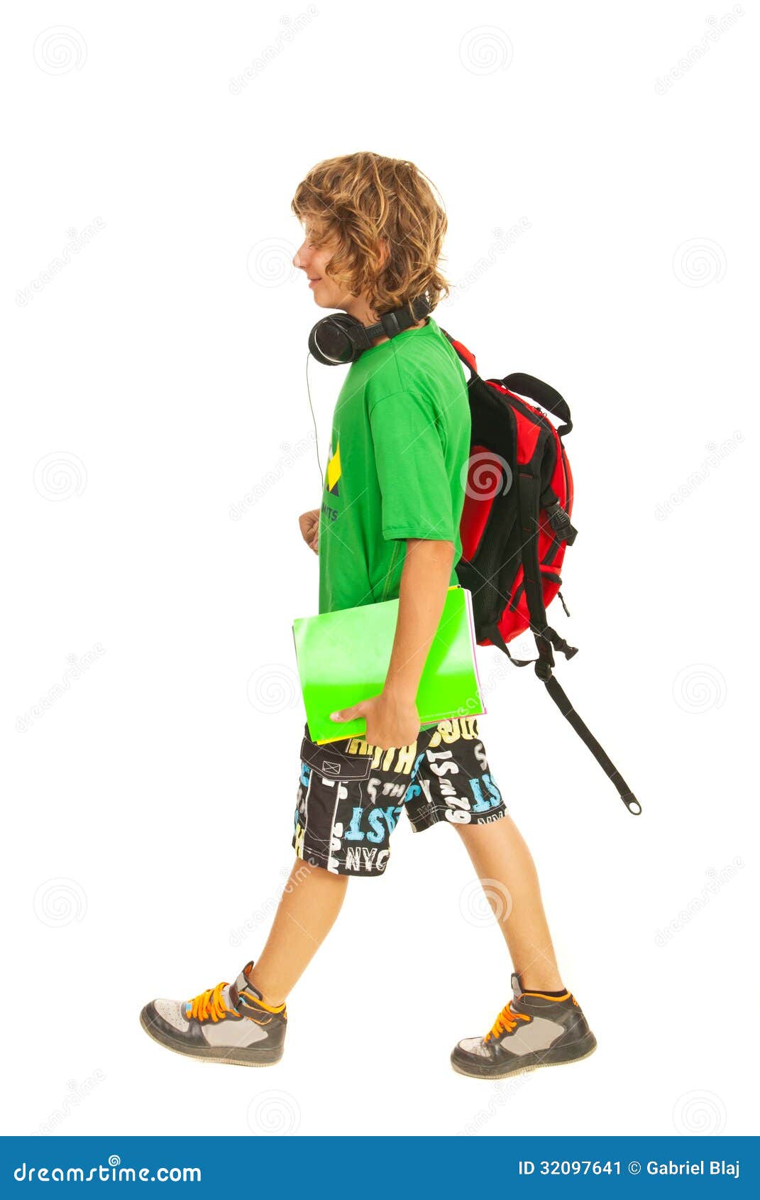 上学的青少年的男孩. 青少年的在白色背景隔绝的男孩上学和拿着笔记本的和袋子