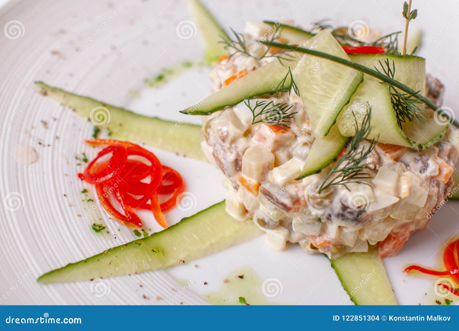 与菜和肉的俄国传统沙拉奥利维尔 在一个白色盘的沙拉在桌上 婚姻正餐肉卷熏制的蕃茄
